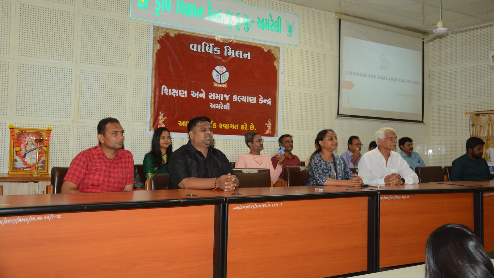 Members seated at the table at SSKK’s annual meeting in Amreli, the organisation’s banner behind them
