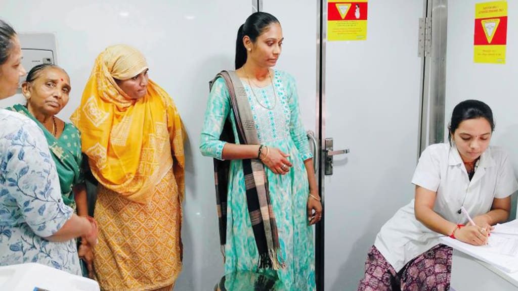 Women waiting at a cancer detection camp registration desk