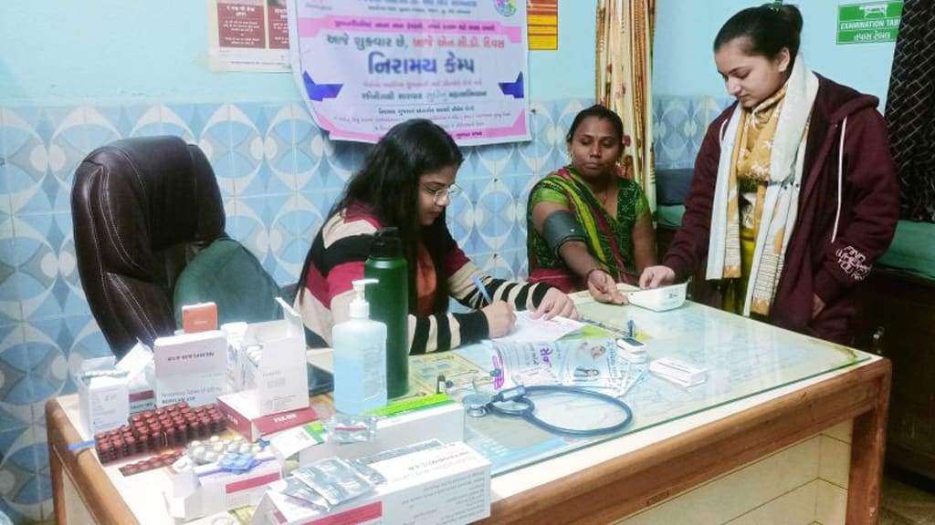 A physician consulting with a woman at a village health camp
